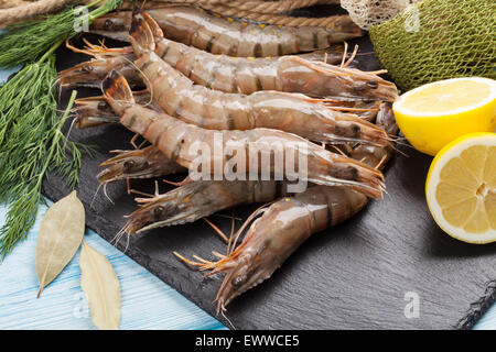 Crudo fresco gamberoni e attrezzature per la pesca sul tavolo di legno Foto Stock