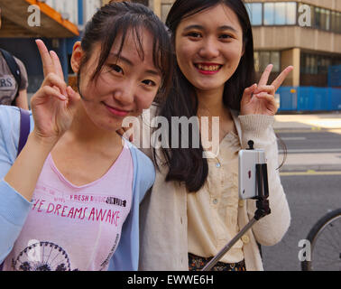 Due belle donne asiatiche dando "V" segno Foto Stock