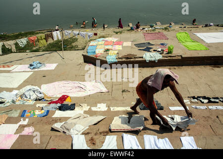 Immissione lavaggio,lavare,vestiti, fuori ad asciugare al sole sulla balneazione ghats,lavato sulle pietre in corrispondenza del bordo del sacro,inquinato,fiume,Gange, Foto Stock