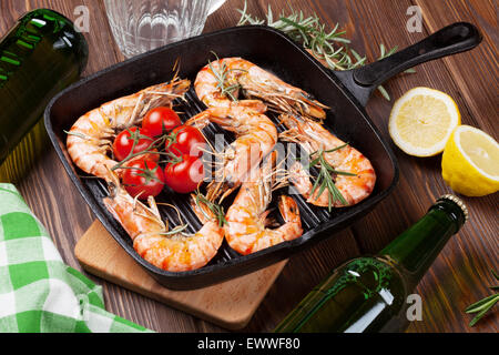 Grigliata di gamberi in padella e birra sul tavolo di legno Foto Stock