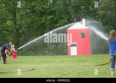 In Ontario, Canada. 01 Luglio, 2015. Un vigile del fuoco da Brock Township Fire Dept mostrano una giovane ragazza come utilizzare un incendio in casa una dimostrazione presso il Cannington Canada alle celebrazioni del Giorno in Cannington Ontario luglio 1/2015 Credito: Jill Morgan/Alamy Live News Foto Stock