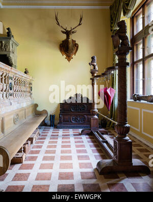 Rivestimento di ornati e portaombrelli in castello guardaroba con montata la testa di cervo e di legno lunghi ad alta sostenuta da banco Foto Stock