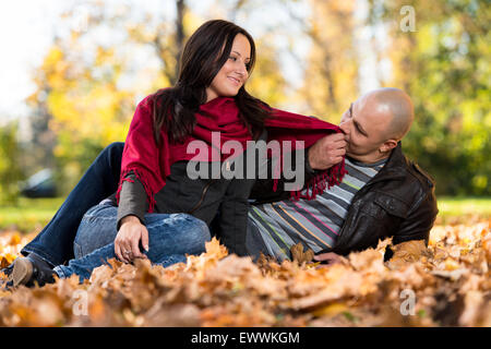 Affascinante giovane seduto insieme al parco Foto Stock