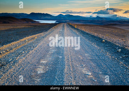 Strada che conduce nella distanza sotto un cielo drammatico Foto Stock