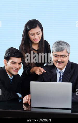 3 Indian business partner di discussione per laptop Foto Stock