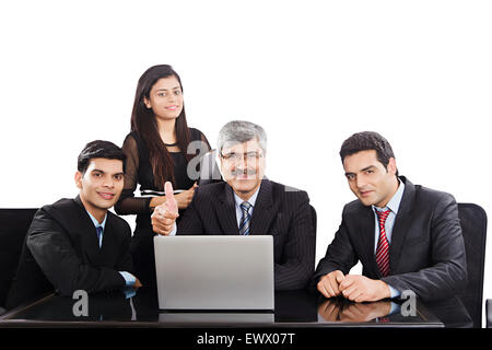 4 Indian business partner discussione laptop pollice in alto mostra Foto Stock