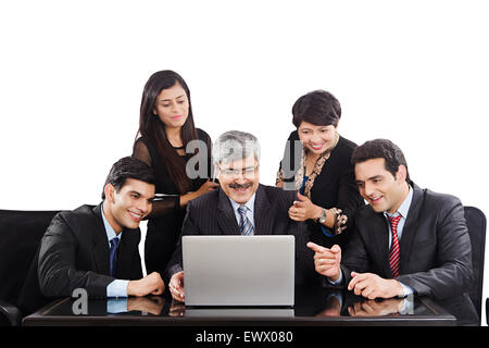 4 Indian business partner di discussione per laptop Foto Stock