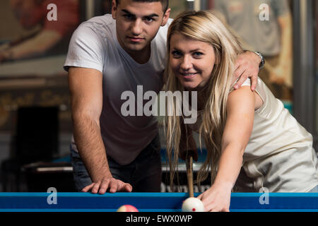 Matura in un night club giocando a biliardo Foto Stock