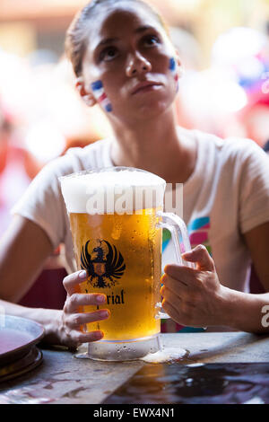 Un bar gara trafitta dalla coppa del mondo del gioco del calcio guarda la televisione mentre si serve di un boccale di birra imperiale Tamarindo, Costa Rica Foto Stock