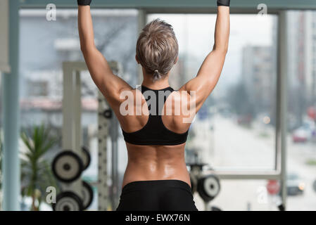 Atleta femminile facendo tirare Ups - Chin-Ups In Palestra Foto Stock