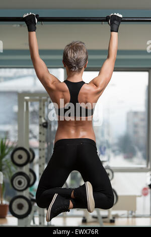 Atleta femminile facendo tirare Ups - Chin-Ups In Palestra Foto Stock