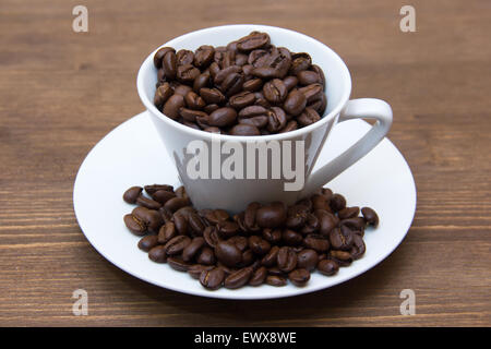 Cup con i chicchi di caffè sul tavolo in legno Foto Stock