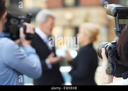 Fotografo a scattare foto di giornalista intervistando il proprietario Foto Stock