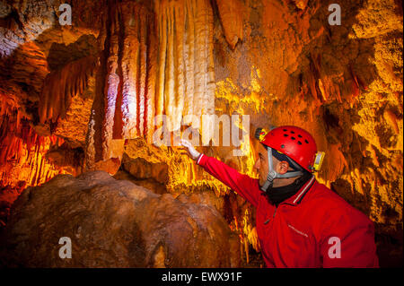 Italia Puglia Castellana Grotte - La speleologo Sergio Carpinelli mostra la colorazione di alcune stalattiti rosa e bianco Foto Stock