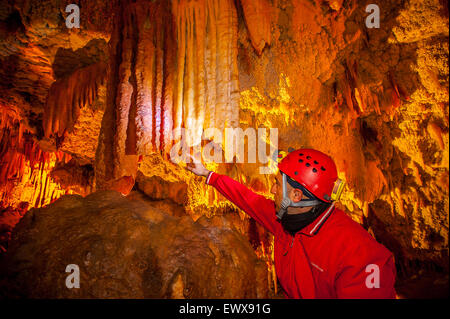 Italia Puglia Castellana Grotte - La speleologo Sergio Carpinelli mostra la colorazione di alcune stalattiti rosa e bianco Foto Stock