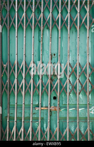 Vecchio di piegatura porta di metallo porta del negozio abbandonati Foto Stock