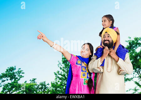 Indian Punjabi genitori e figlia park il dito puntato Foto Stock