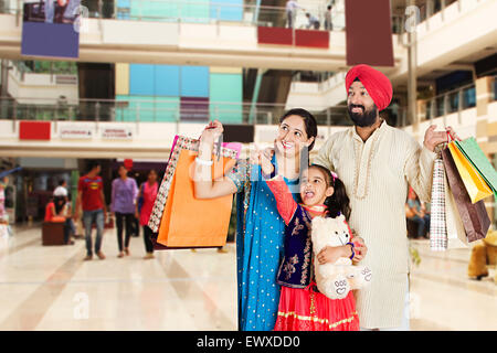 Indian Punjabi genitori e figlia mall shopping puntare il dito Foto Stock