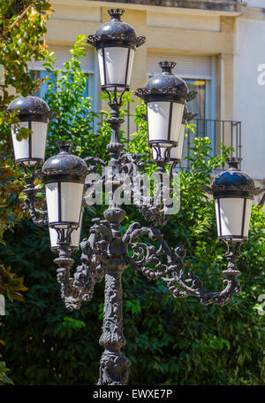 Lampada di antiquariato con letti in ferro battuto con ornamenti Foto Stock