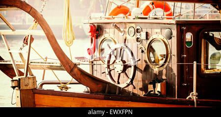 Retro Vintage filtrata foto della vecchia barca a vela ponte con volante in legno. Foto Stock