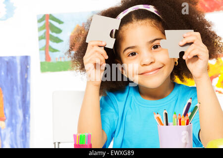 Ritratto di giovane ragazza africana tenendo i pezzi del puzzle Foto Stock