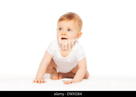 Guardando stupito piccolo bambino su la coltre bianca Foto Stock