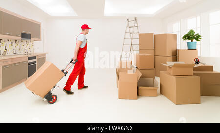 Deliveryman caucasici in rosso uniforme tenendo la mano carrello, erogazione di scatole a casa nuova Foto Stock