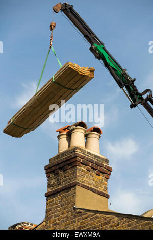 Legname / Legno / assi / travetto / travetti erogata da una gru a una casa in roof top / nuova estensione dorma. Regno Unito Foto Stock