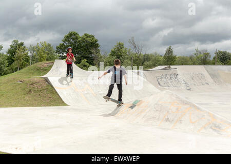 Due ragazzi adolescenti utilizzando uno skateboard park in Cannington, Ontario Canada Foto Stock