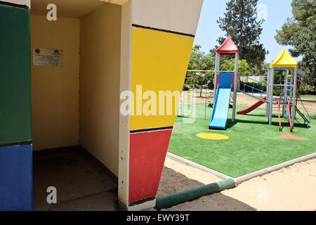 Frontiera Gaza, Israele. 2 Luglio, 2015. Calcestruzzo al di sopra del suolo shelters adiacente ad un parco giochi per bambini garantiscono sicurezza per coloro che sono abbastanza veloci per raggiungere in caso di un codice sirena rossa indicante Razzi in arrivo nel Kibbutz Magen, situato a 4,5 Km dalla frontiera Gaza. A un anno dal funzionamento bordo protettivo, lanciata da Israele contro Hamas ha governato la striscia di Gaza, frontiera israeliana europee si sforzano di tornare alla vita normale ma costante paura e ci aspettiamo che il prossimo round delle ostilità. Credito: Nir Alon/Alamy Live News Foto Stock