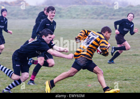 Ragazzi locali partita di rugby St. David's(arancione e nero) v Neyland, tenutosi a St. David's club di rugby su un umido/giorno di pioggia. Su Pembrokeshi Foto Stock