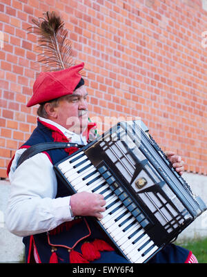 Musicista di strada indossavano nel tradizionale abito in Polonia la riproduzione sulla strada di Cracovia. Foto Stock