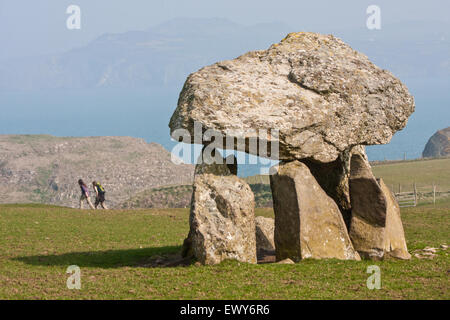 Due, escursionisti, escursionista, a piedi, a piedi, sul Pembrokeshire Coast Path, passando CAREG Sampson (Carreg Samson) dolmen / camera di sepoltura, Galles del Sud-Ovest, Galles del Galles del Galles del Galles del Galles del Galles del Galles, Regno Unito Foto Stock