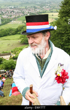 Maestro delle cerimonie. Egli dà i motorini di avviamento e gli ordini di rotoli i formaggi.Formaggio a rotolamento Coopers Hill, Brockworth, Gloucesters Foto Stock