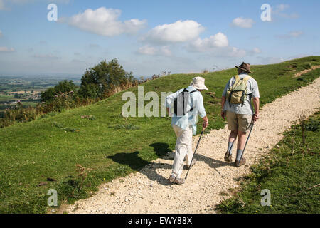 Gli escursionisti/ walkers vicino villaggio Uley, escursioni fino a lungo a camma in discesa con il Costwolds, sul famoso sentiero nazionale 100 mile Cotswold Foto Stock