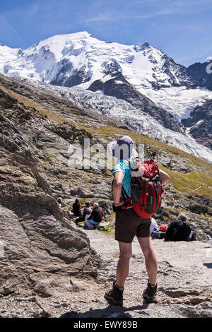 Gli escursionisti al di sopra di Chamonix Mont Blanc valley, Francia. Massiccio del Monte Bianco in mountain range in background. Agosto. Foto Stock