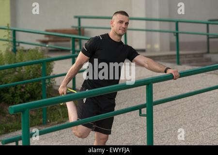 Istruttore di Fitness Portrat all'aperto facendo esercizi streching Foto Stock