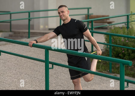 Istruttore di Fitness Portrat all'aperto facendo esercizi streching Foto Stock