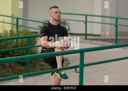 Istruttore di Fitness Portrat all'aperto facendo esercizi streching Foto Stock