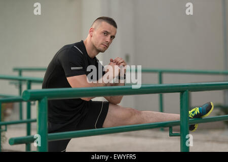 Istruttore di Fitness Portrat all'aperto facendo esercizi streching Foto Stock