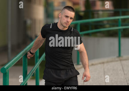 Istruttore di Fitness Portrat all'aperto facendo esercizi streching Foto Stock