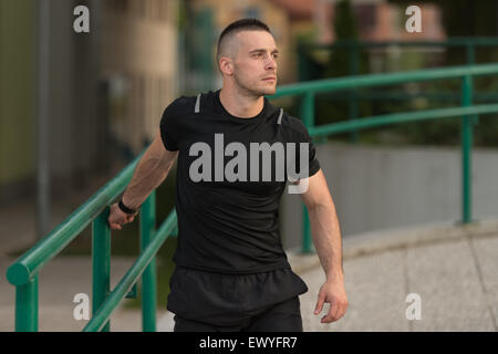 Istruttore di Fitness Portrat all'aperto facendo esercizi streching Foto Stock