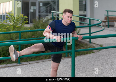 Istruttore di Fitness Portrat all'aperto facendo esercizi streching Foto Stock