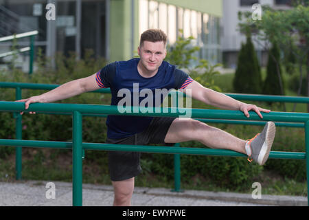 Istruttore di Fitness Portrat all'aperto facendo esercizi streching Foto Stock