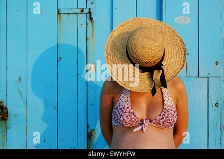 Donna incinta che indossa un cappello di paglia Foto Stock