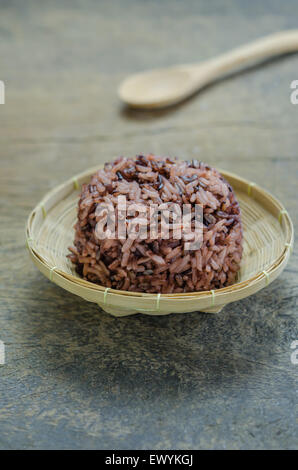 Riso cotto di Riceberry nel cestello di bambù sul tavolo di legno Foto Stock