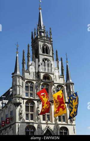 Bandiere volare dal municipio di Gouda nei Paesi Bassi. L'edificio in stile gotico risale alla metà del XV secolo. Foto Stock