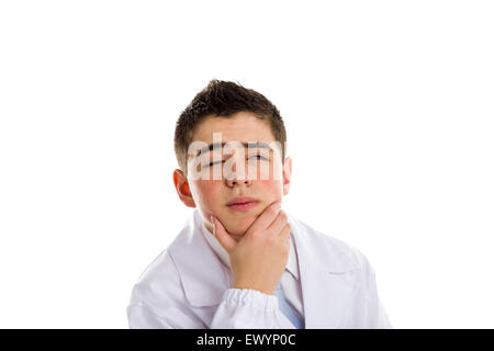 Un ragazzo medico in cravatta blu e mantello bianco tenendo la sua mento mentre pensare. La sua pelle acne non ha ben ritoccata Foto Stock