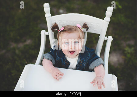 Ritratto di bambina in sedia alta Foto Stock