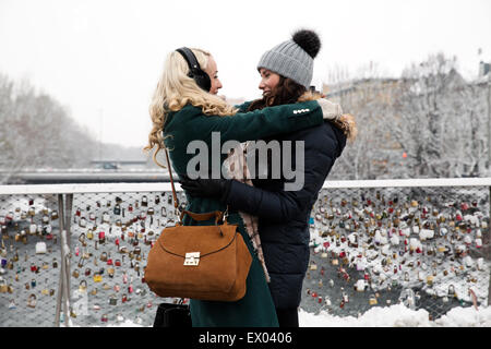 Due metà donne adulte abbracciando sul ponte Foto Stock